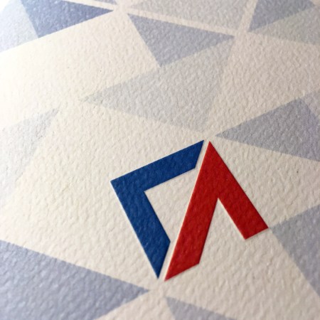 The cover of the bifolded invitation included an embossed logo, created using a custom fabricated press.