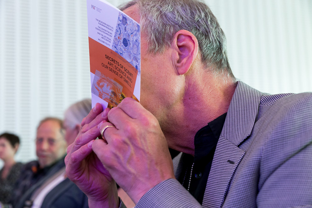 A guest enjoys the scratch-n-sniff event program cover.